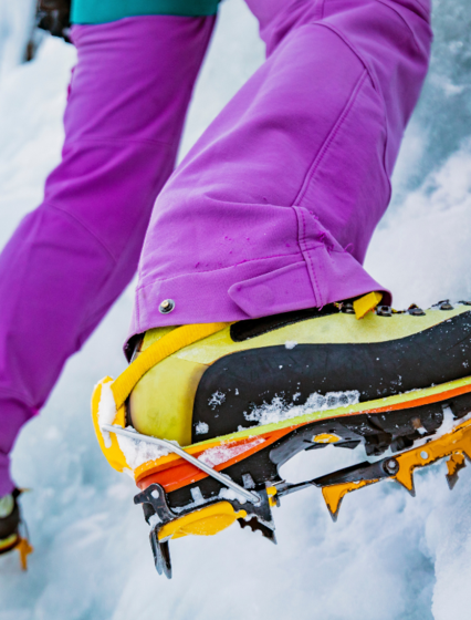 Close up of ice climber's crampons on ice