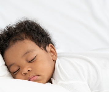 Image of sleeping baby on white bed sheets