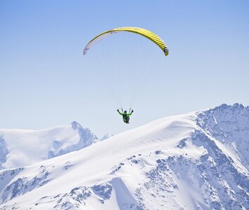 Paragliding above snowy slopes