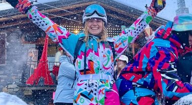 Girl dancing in ski kit with beer in hand