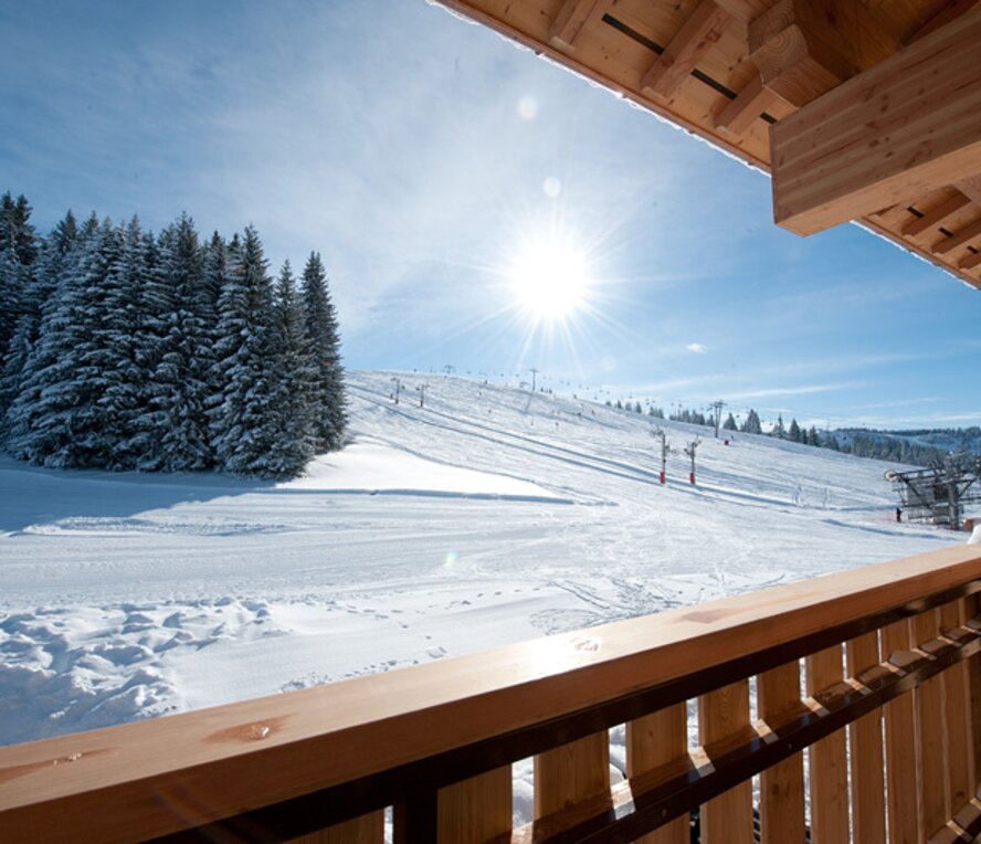 view of the piste and ski lifts from chalet balcony in Les Gets
