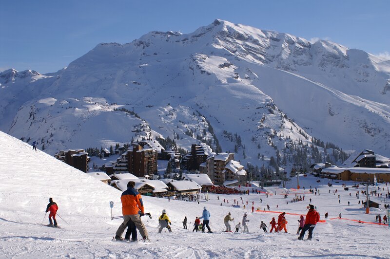 View of skiers skiing down into Avoriaz on a sunny day