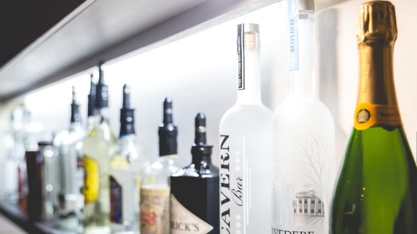Row of alcoholic drinks bottles lined up behind bar