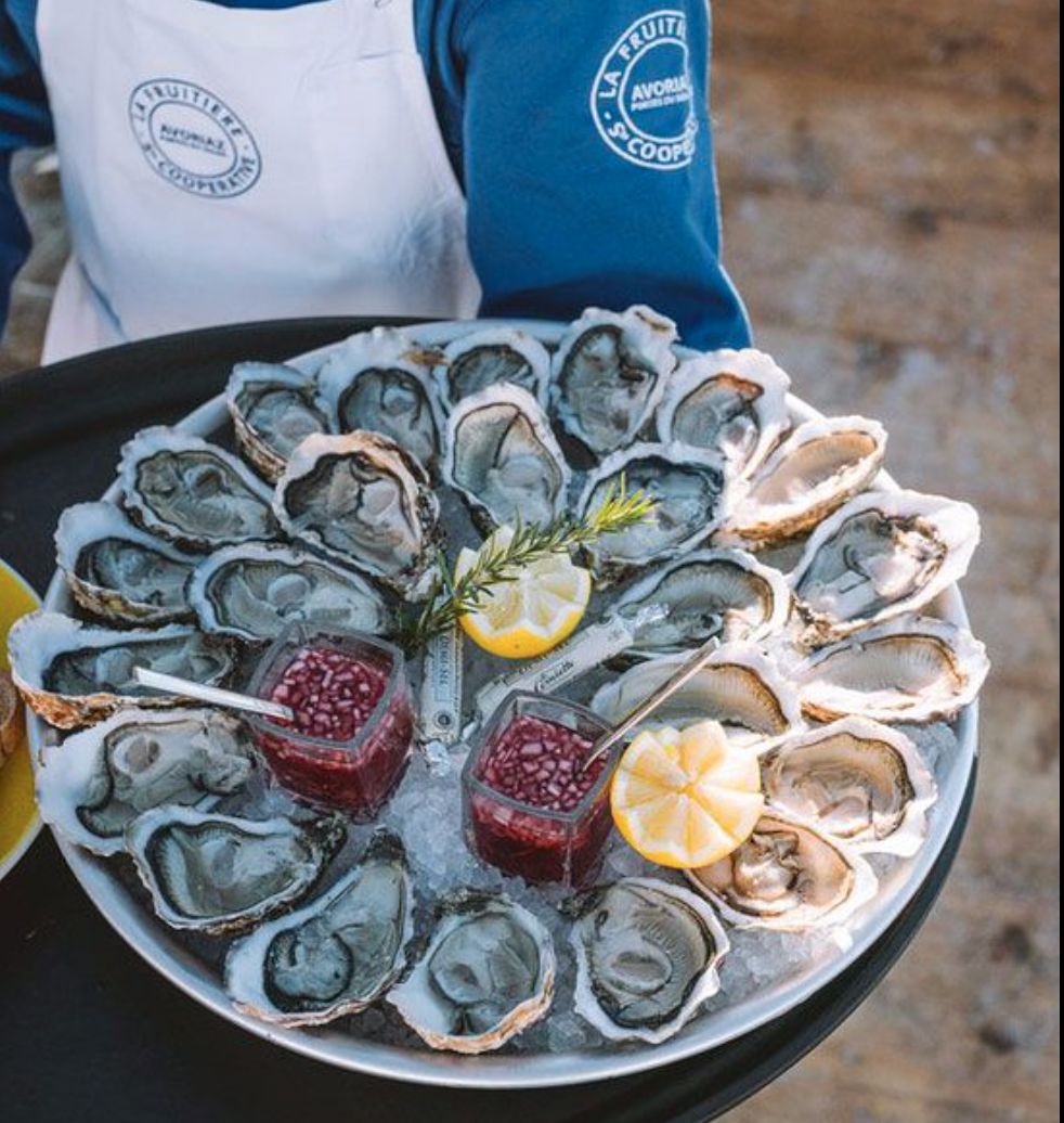 Fuitiere waiter holding plate of oysters