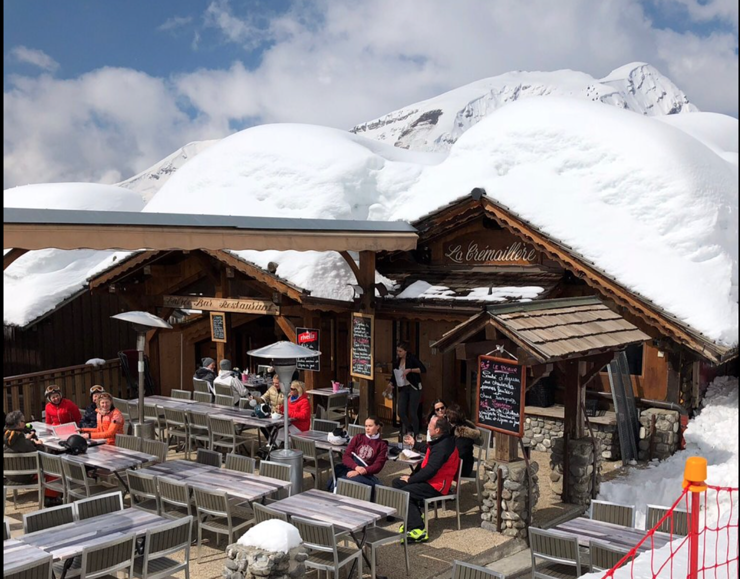 Terrace outside mountain restaurant with lots of snow on roof