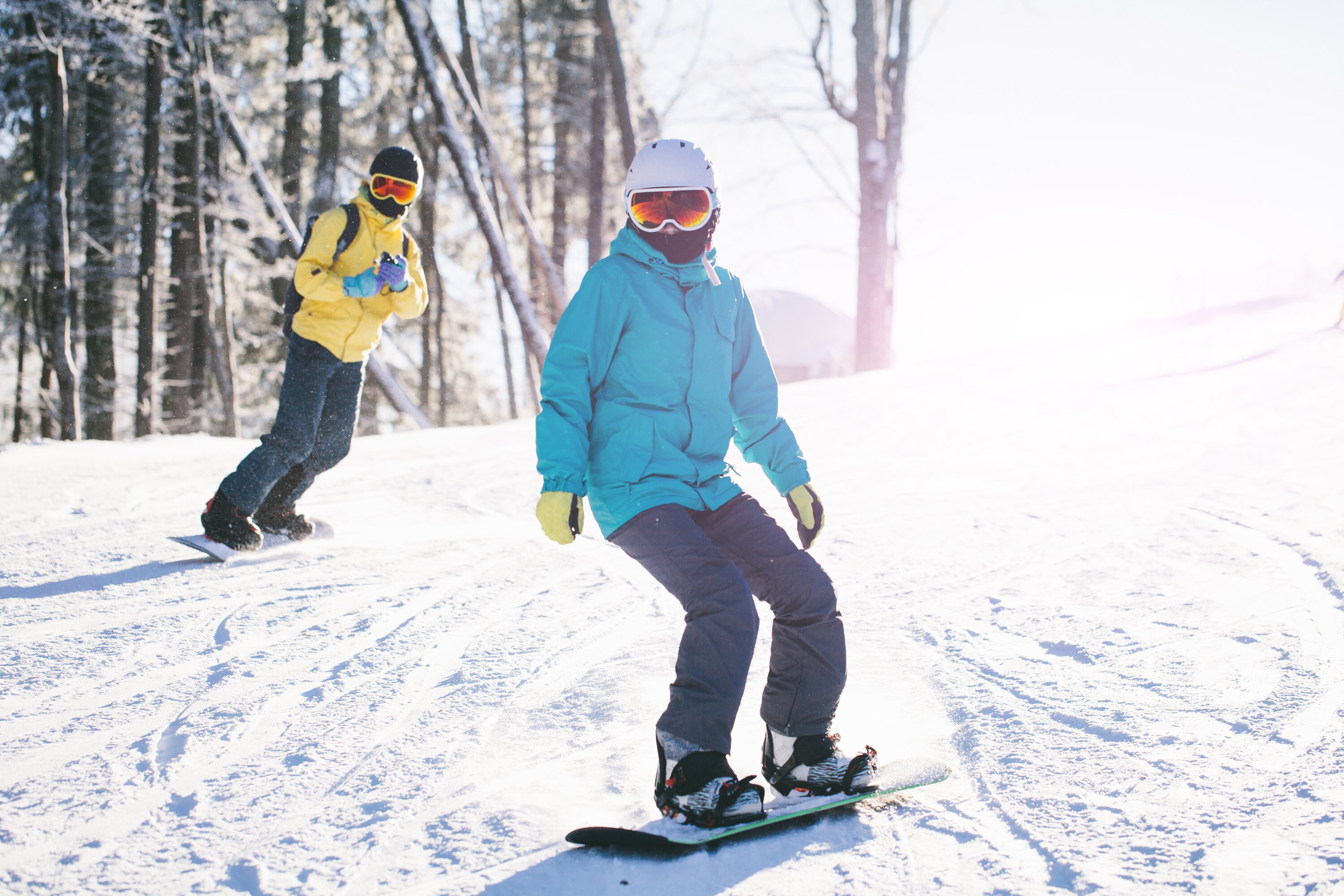 Two snowboarders in sunshine on snowy slope