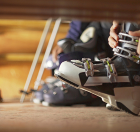 Skier doing up ski boots in boot room