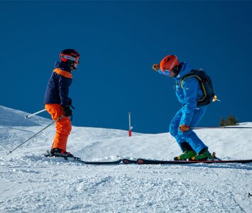Ski instructor teaching skier on sunny day