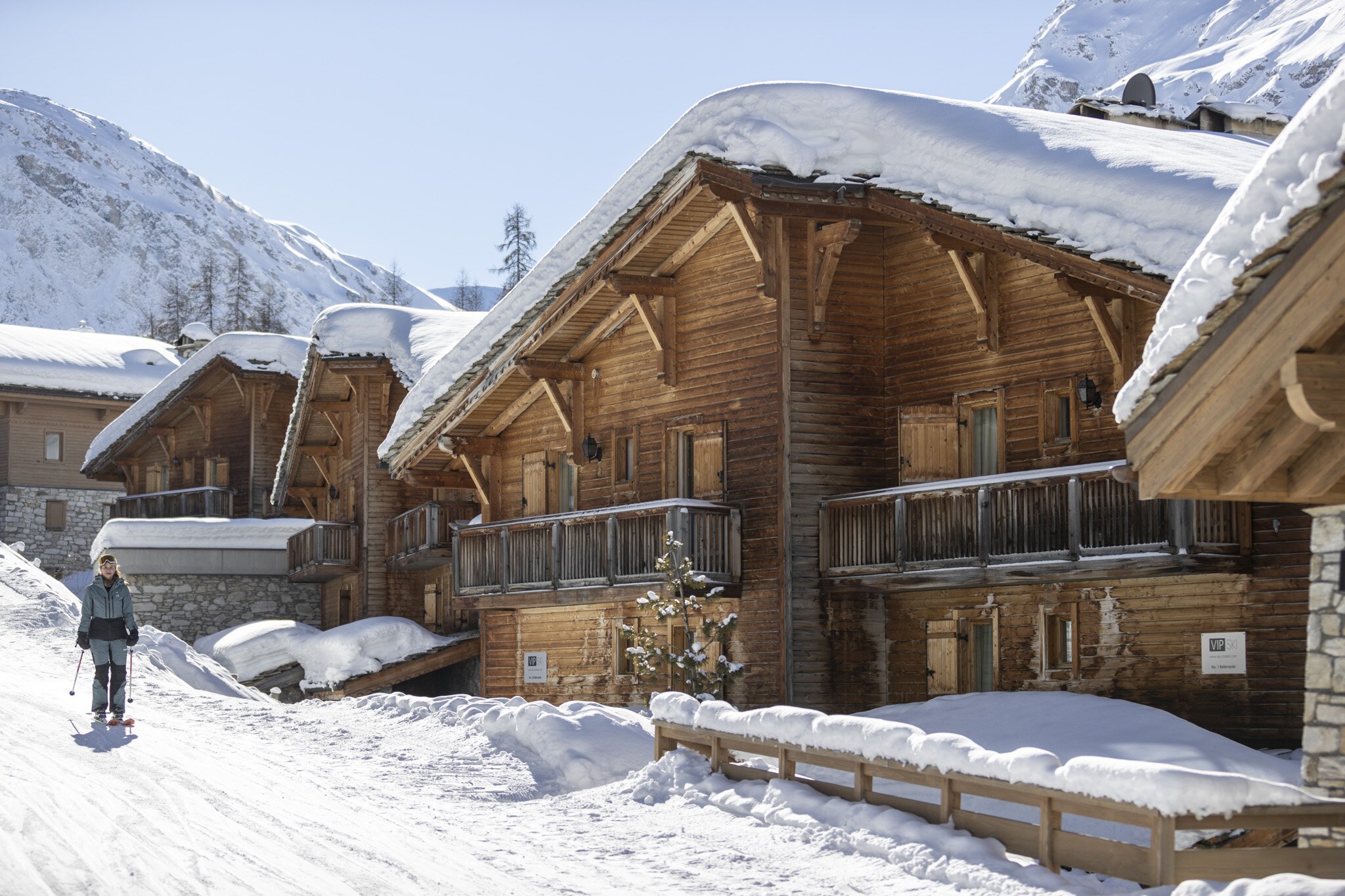 Female skier skiing past VIP SKI chalets in Val d'Isere