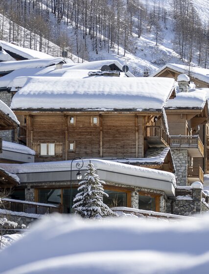 Exterior of snowy VIP SKI Bellevarde chalets in Val d'Isere on sunny day