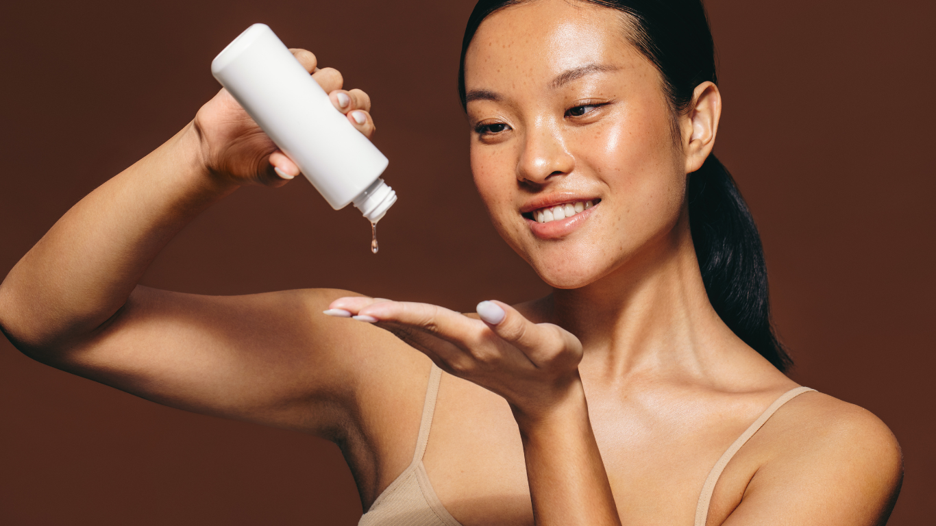 Smiling woman pouring skincare product out of bottle onto hand