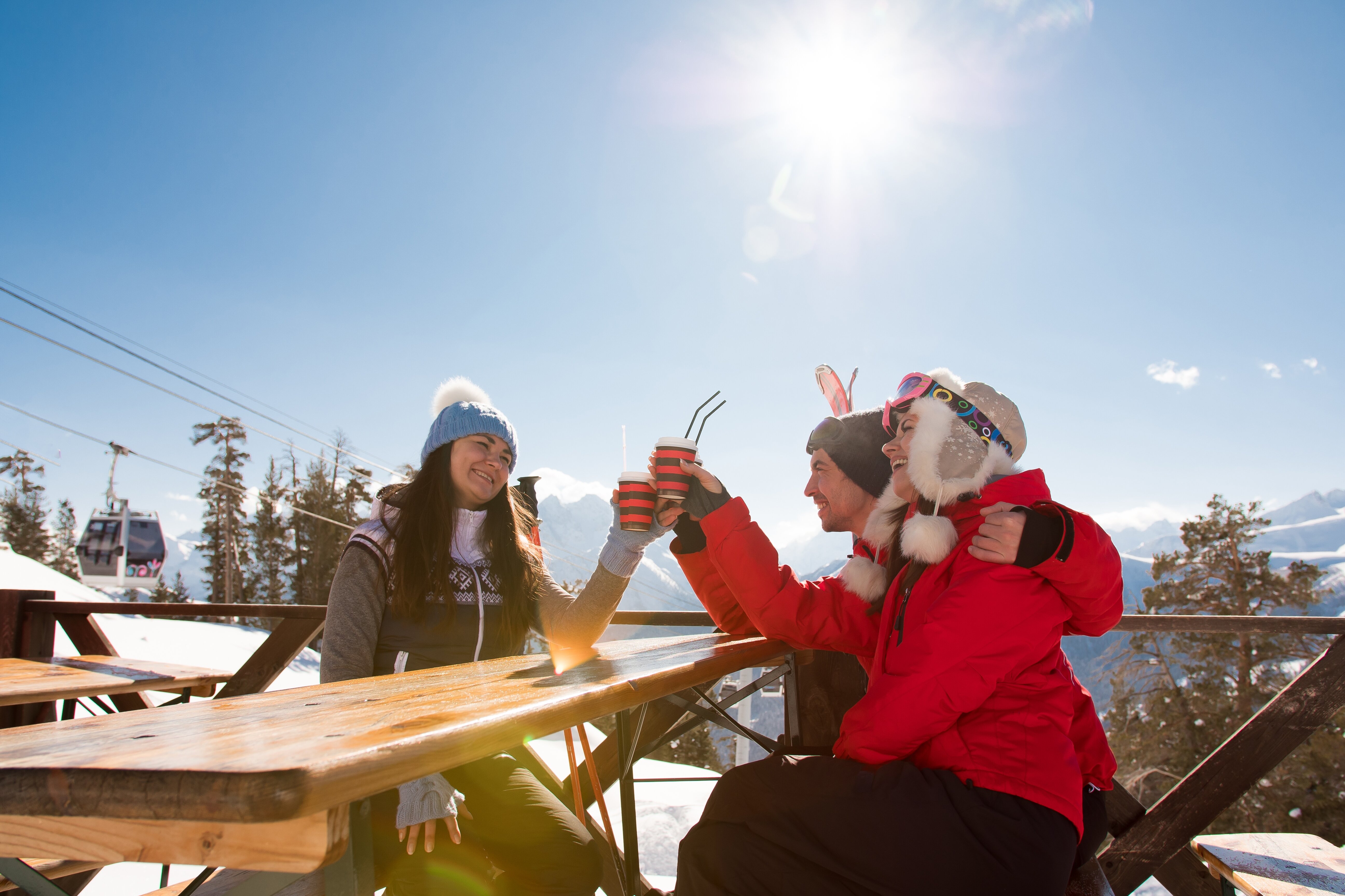 Friends enjoying apres ski on a sunny restaurant terrace