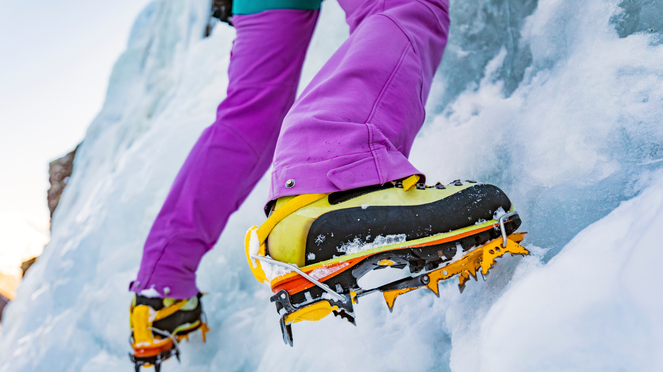 Close up of ice climber's crampons on ice