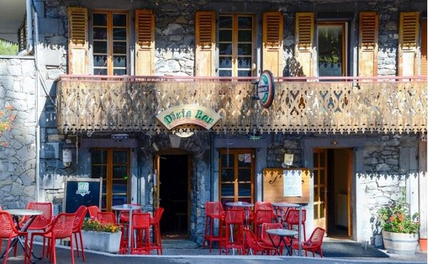 Exterior of Dxie Bar in Morzine with red chairs and tables outside