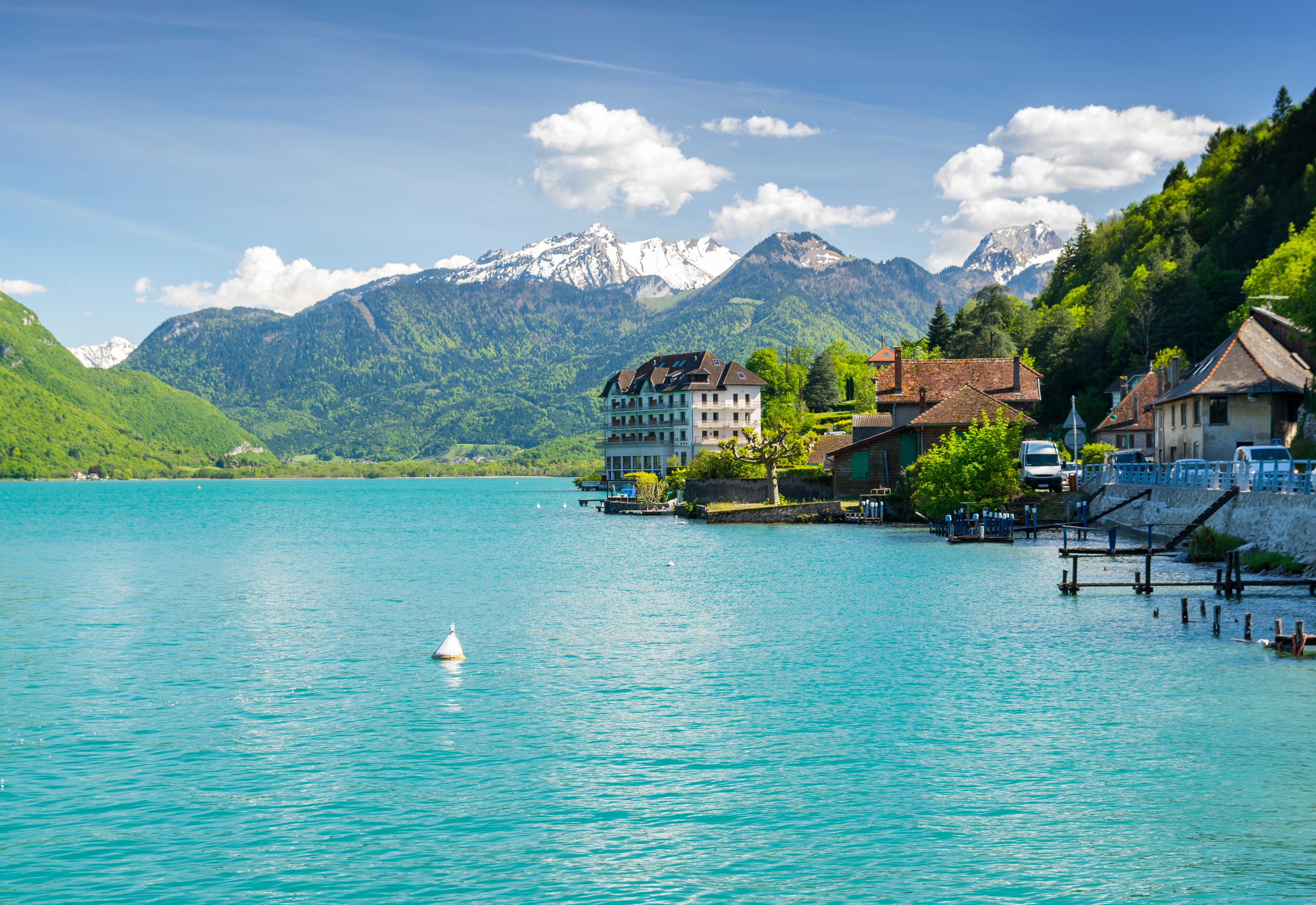 Lake Annecy with turquoise water and snow-capped mountains in the background