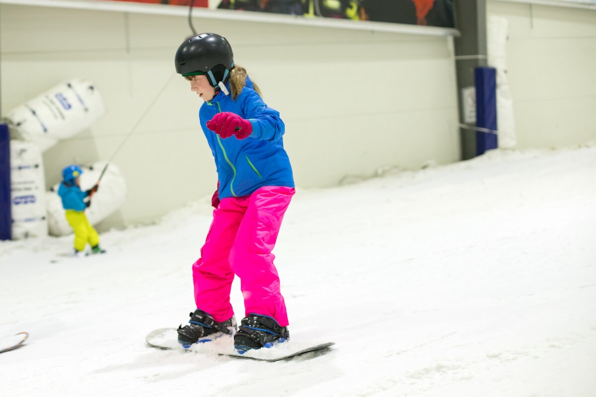 Young girls snowboarding in indoor ski centre