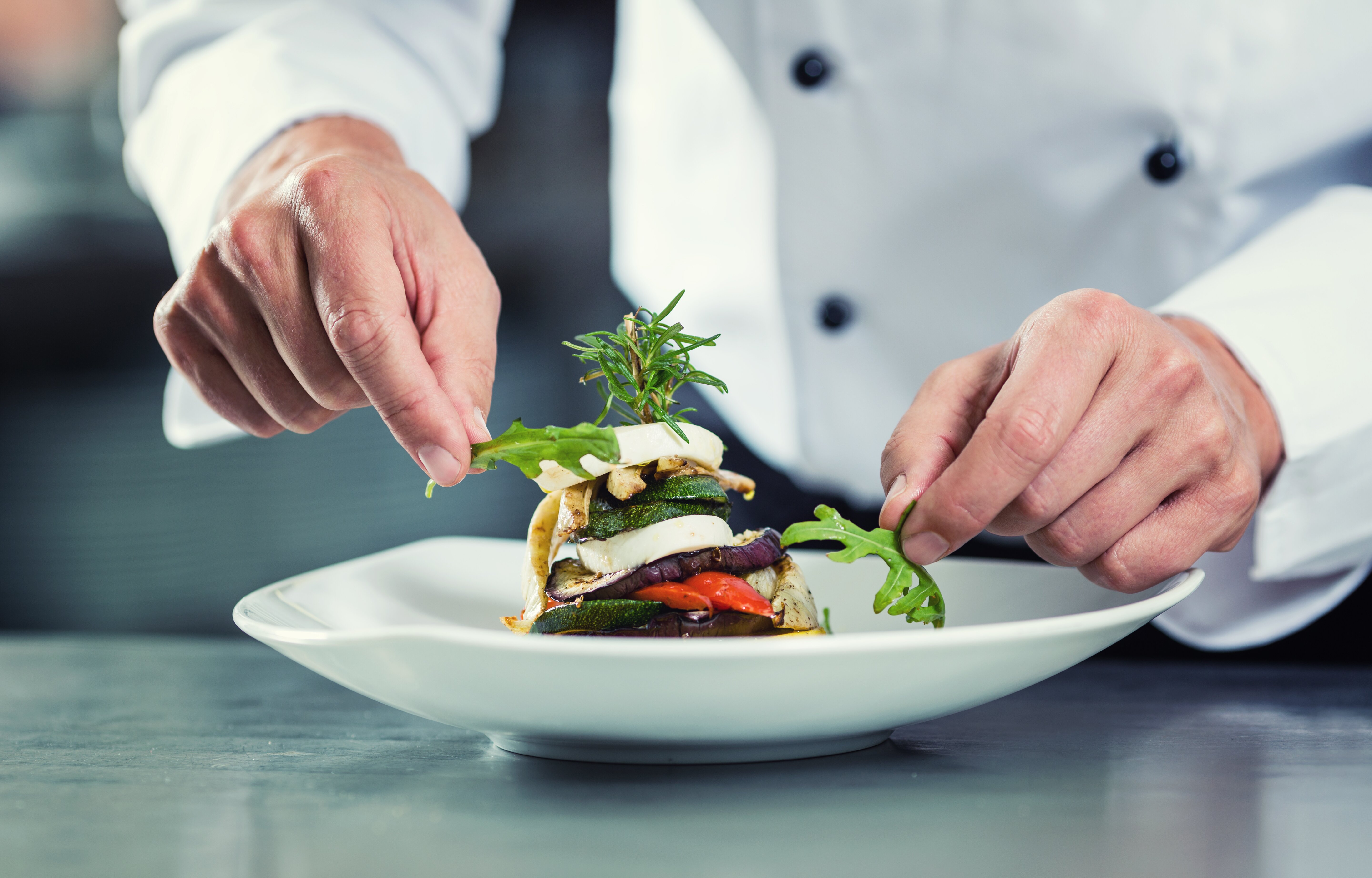 chef adding garnish to a plate