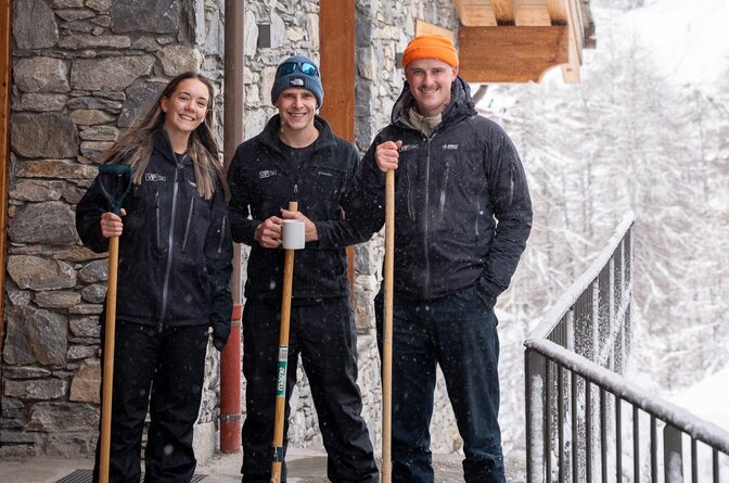 three members of VIP SKI staff stood outside a chalet with snow shovels