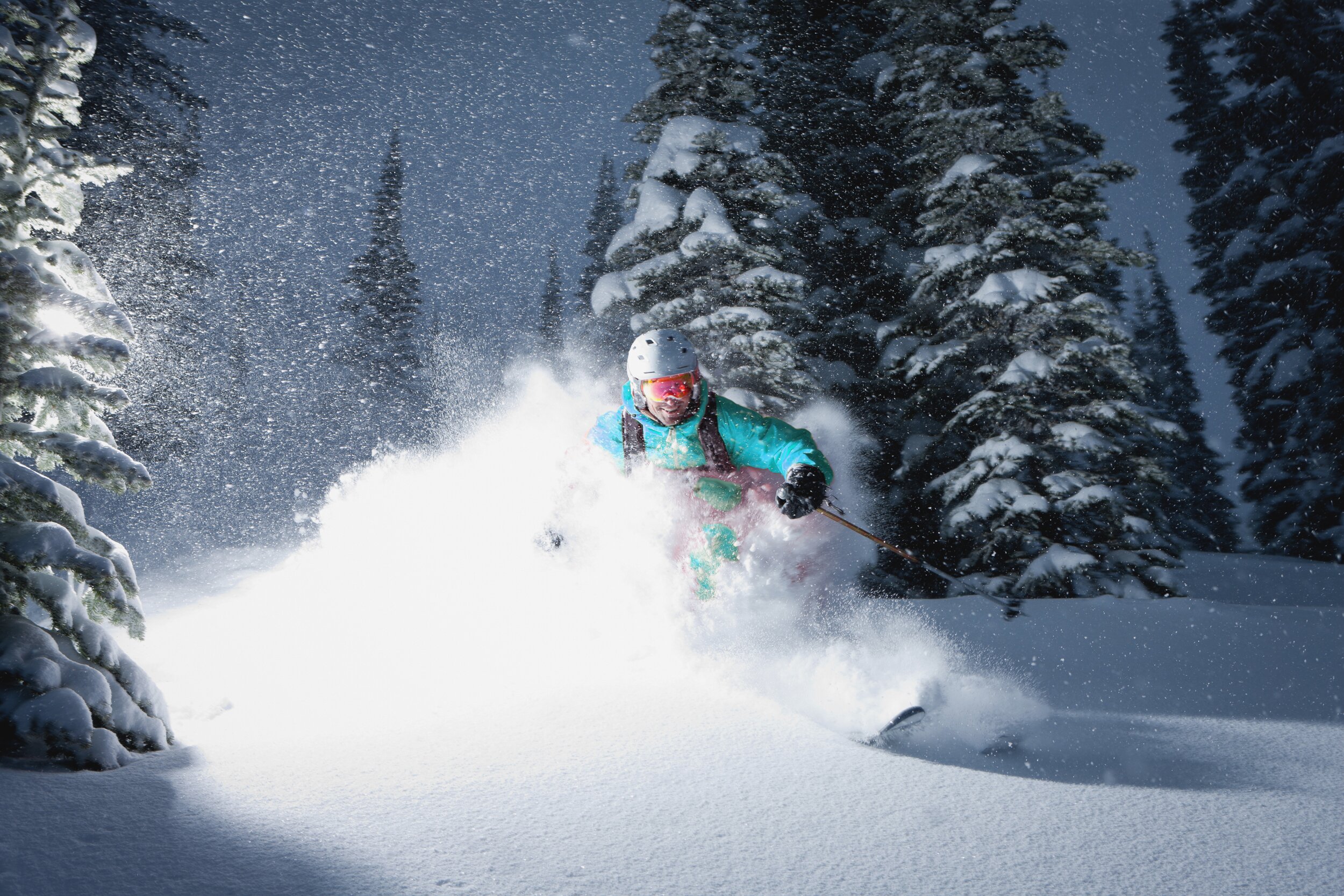 Smiling male skiing powder at night time
