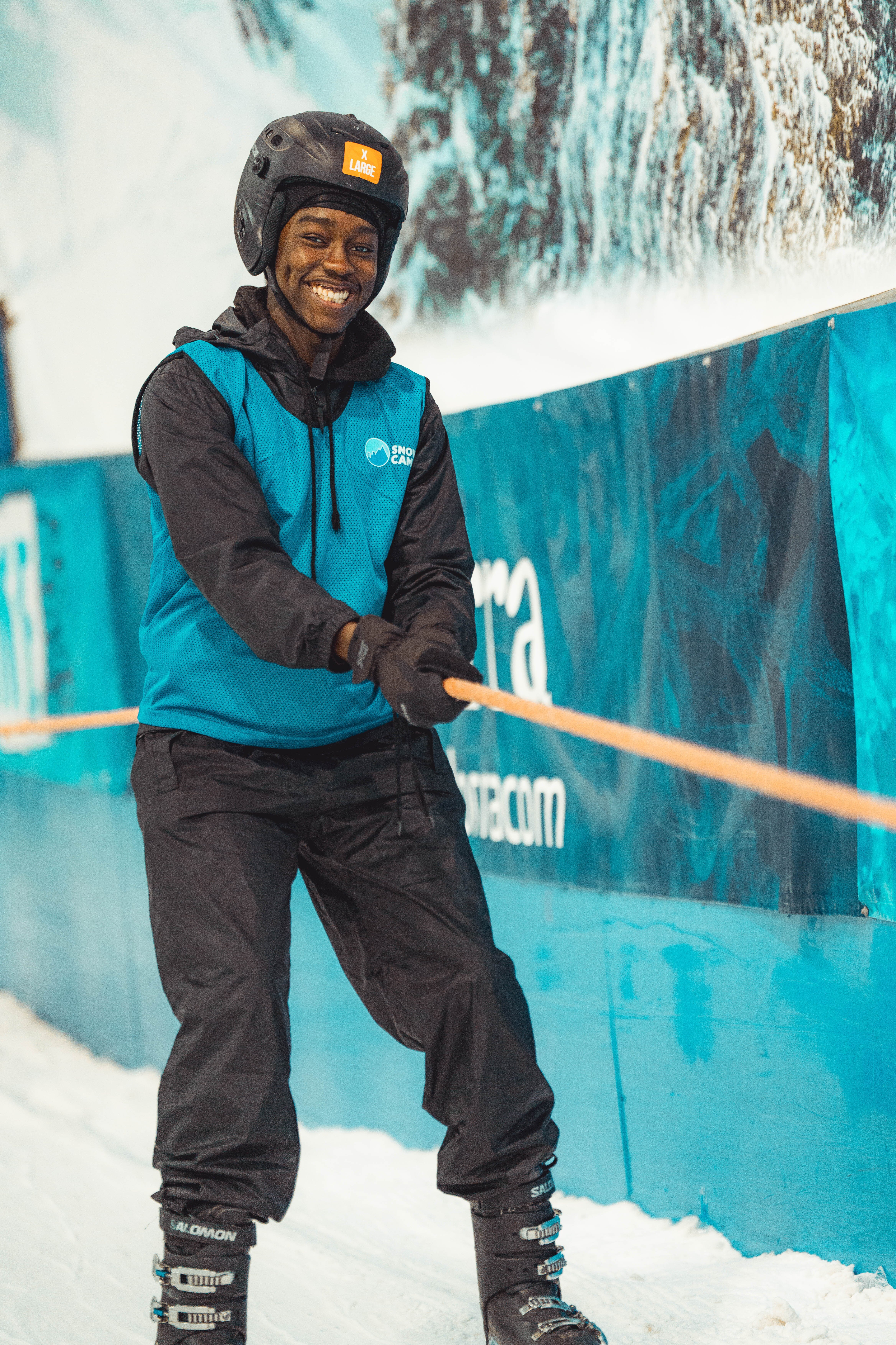 Smiling young boy holding on to rope tow at indoor snow centre