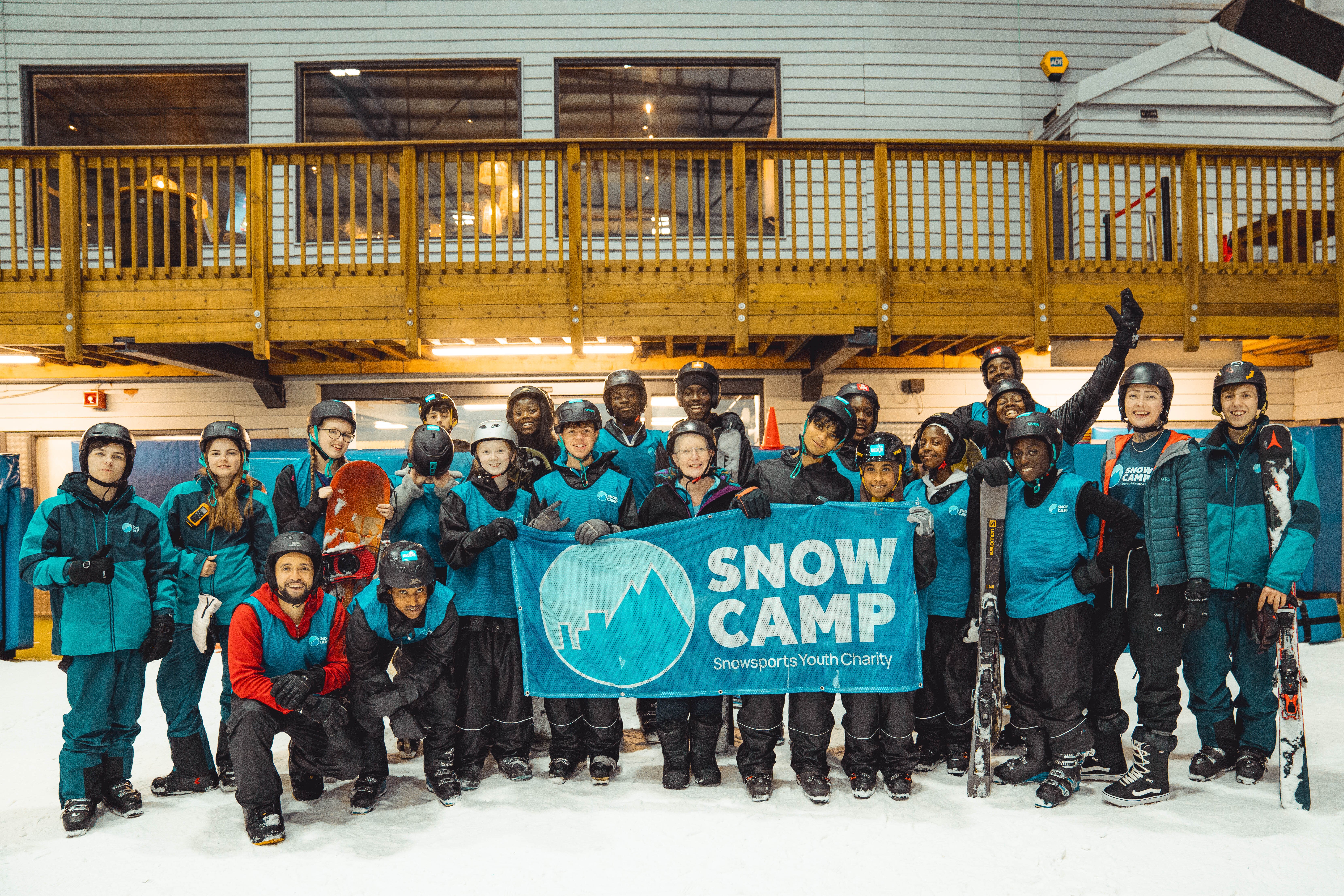 Group of Snow Camp young people holding Snow Camp banner at indoor snow centre