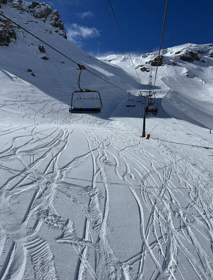 Lanches chairlift in Tignes in April with quiet piste and powder snow beneath chairlift