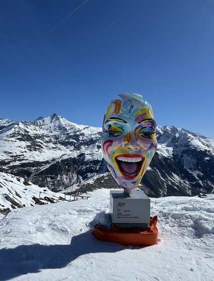 Colourful sculpture of woman's face at top of ski slope in Tignes