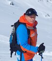 Sylvain, ski instructor wearing Oxygene blue and orange uniform at top of ski slope