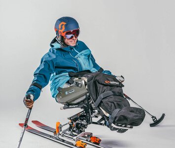 person doing solo sit skiing 