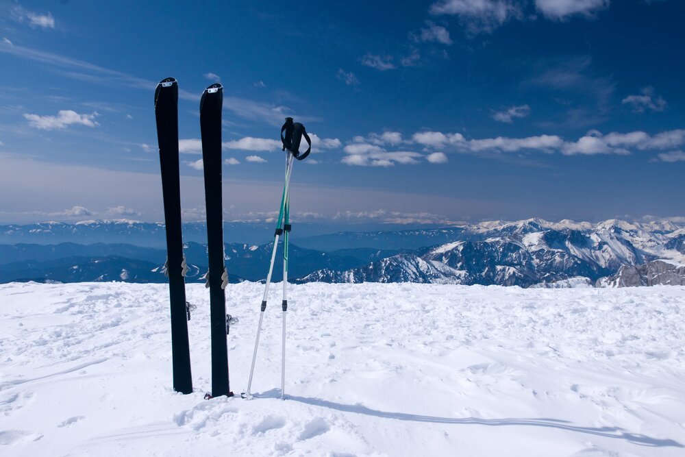 skis in snow with mountains in the background
