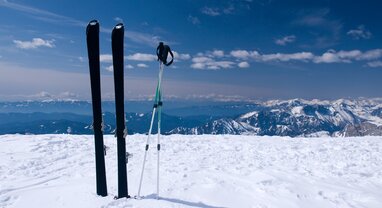 skis in snow with mountains in the background