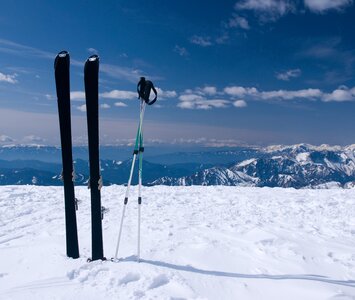 skis in snow with mountains in the background