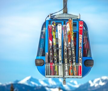 skis on side of a cable car with mountains in background
