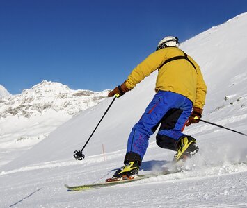 man doing telemark skiing with mountains in background 