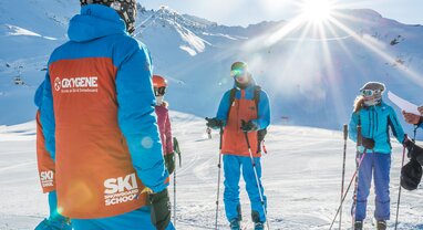 oxygene ski instructors snow covered mountain in background 