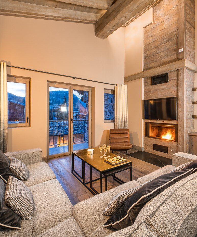 Contemporary living area in chalet apartment with fire lit and champagne and canapes