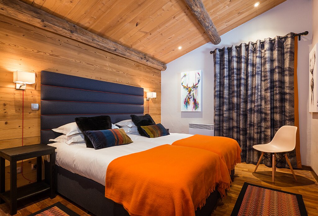Double bed with orange throws at foot of bed in No 3&4 CLUB Bellevarde in Val d'Isere