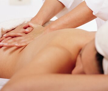 Woman having back massaged