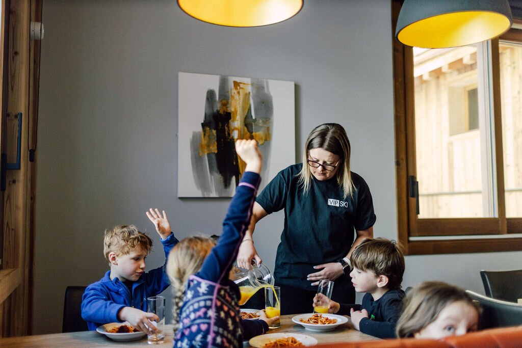 VIP SKI nanny pouring drinks at lunchtime for children in childcare